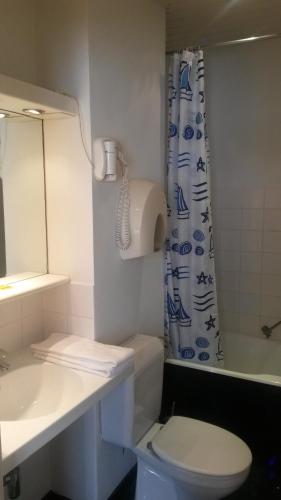 a bathroom with a sink and a toilet and a shower at Hotel Queen Mary in Brussels