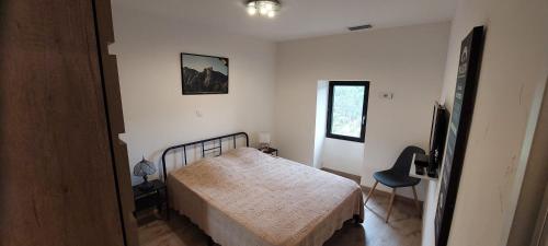 a small bedroom with a bed and a chair at Gîte de Laulagne in Ribes