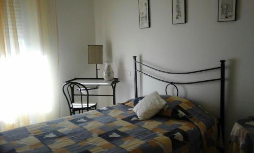 a bedroom with a bed and a table with a chair at Appartamento Piazza Buzi in Orvieto