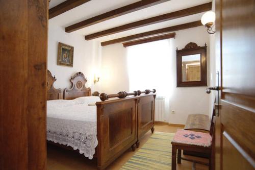 een slaapkamer met een houten bed en een raam bij Villa Dabo in Novalja