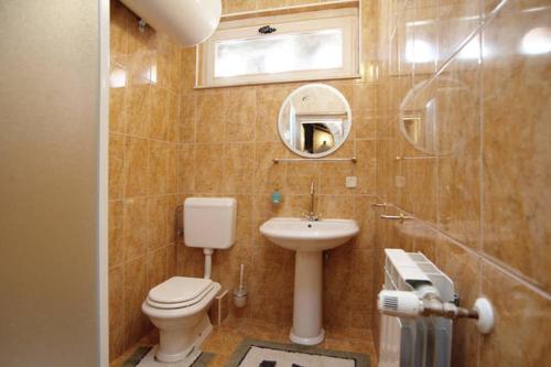 een badkamer met een toilet, een wastafel en een spiegel bij Villa Dabo in Novalja