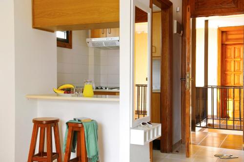 a kitchen with a counter and two stools in a room at Coral Compostela Beach in Playa de las Americas