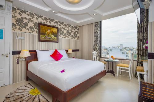 a bedroom with a large bed and a large window at Pink Suite Saigon Airport Hotel in Ho Chi Minh City