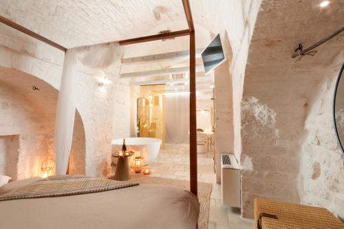 a bedroom with a bed and a tub in a room at Suite Amor in Alberobello