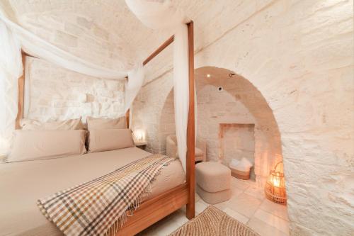 a bedroom with a bed in a stone wall at Suite Amor in Alberobello