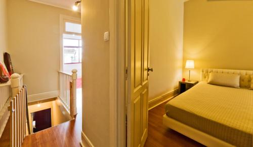 a bedroom with a bed and a hallway with a window at vitoria flat in Porto