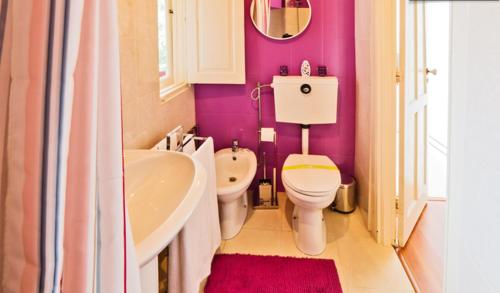 a bathroom with a white toilet and a sink and a tub at vitoria flat in Porto