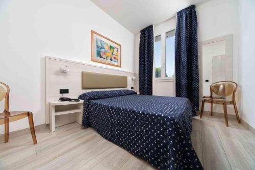 a bedroom with a blue bed and a window at Alloggi Liviana Pontecorvo in Padova