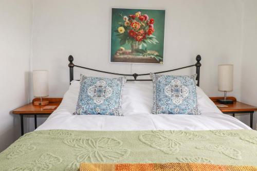 a bedroom with a bed with a painting on the wall at Longview Cottage in Bugle