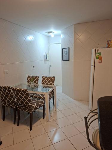 a kitchen with a table and chairs and a refrigerator at Lar doce lar da Lu in Curitiba