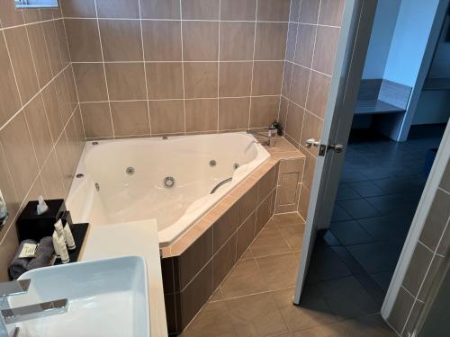 a bathroom with a bath tub and a sink at Acacia Motor Lodge in Coonabarabran