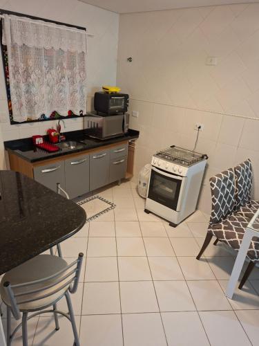 a kitchen with a stove and a microwave at Lar doce lar da Lu in Curitiba