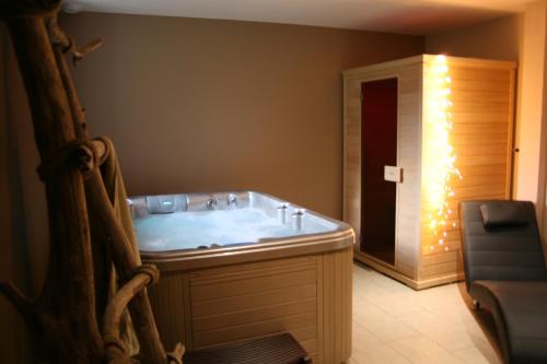 a bathroom with a tub with lights in it at La Maison de Jeanne, maison d'hôtes in Thiézac