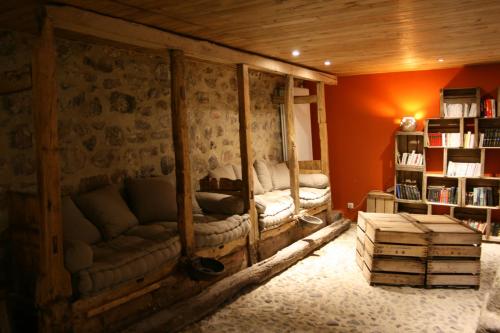 a living room with two couches and a book shelf at La Maison de Jeanne, maison d'hôtes in Thiézac