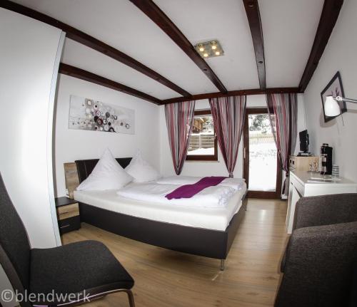 1 dormitorio con 1 cama y 1 silla en Haus Leutner, en Bodenmais