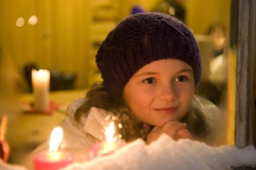 a little girl in a hat looking at candles at Haus Alpenfriede in Ramsau im Zillertal