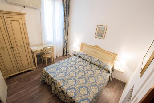 a bedroom with a bed and a table and a desk at Albergo Casa Peron in Venice