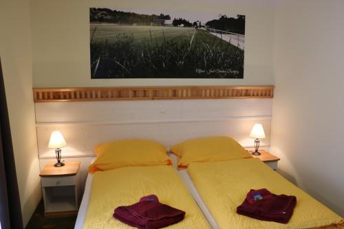 two beds in a small room with two lamps at Gästehaus Alte Bäckerei in Dachwig