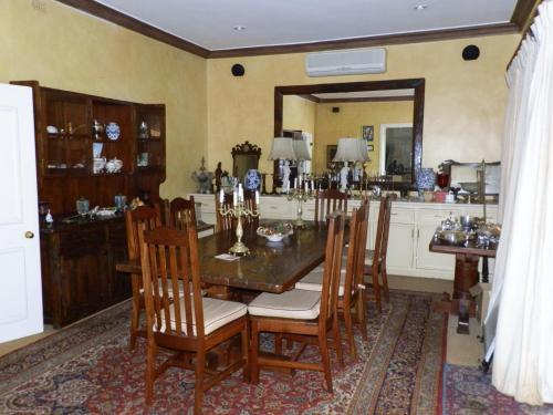 a dining room with a table and chairs and a mirror at 12 FLEETWOOD in Harare