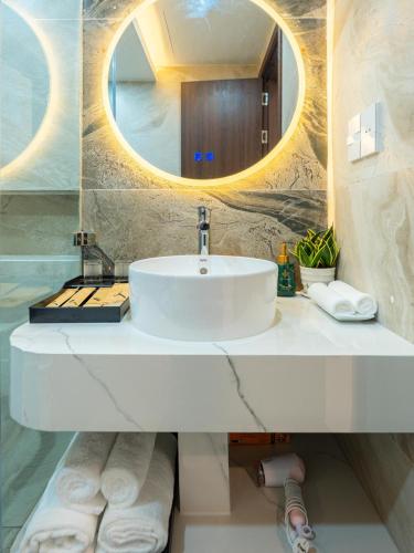 a bathroom with a sink and a mirror and towels at Cactus Villa in Dong Hoi