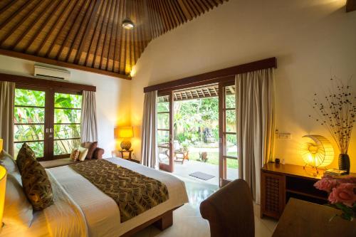 a bedroom with a bed and a large window at Villa Seriska Satu Sanur,a Luxury 4-Bedroom Villa, 5 mins walk to ICON Mall, Beach & 24hrs Security in Sanur