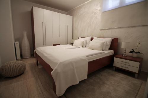 a bedroom with a large bed with white sheets and pillows at Apartments Villa Mantinela in Malinska