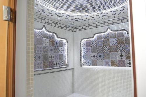 a bathroom with a shower and a window with tiles at Shergiron PLAZA in Bukhara