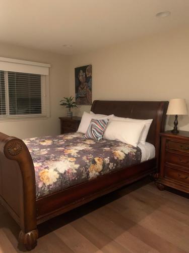 a bedroom with a bed with a floral bedspread at Spacious 3 bedrooms 1 bath Jacuzzi BBQ SINGLE HOUSE in Agoura Hills