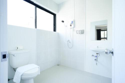 a white bathroom with a toilet and a sink at Snap Sukhumvit 1 - BTS Nana in Makkasan