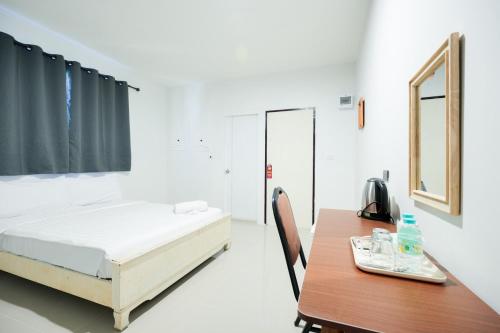 a bedroom with a bed and a wooden table at Snap Sukhumvit 1 - BTS Nana in Makkasan