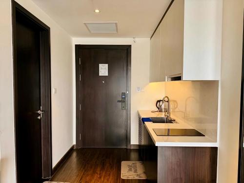 a kitchen with a black door and a sink at Luxury Ocean View Apartments - The Sapphire Ha Long, Studio & 2BR in Ha Long