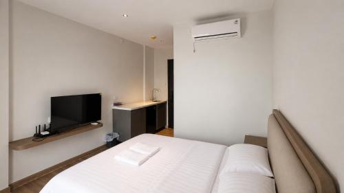 a bedroom with a white bed and a tv at SleepRest Azure Suites in Bagam