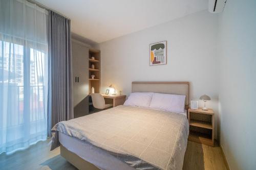 a bedroom with a bed and a large window at SleepRest Azure Suites in Bagam