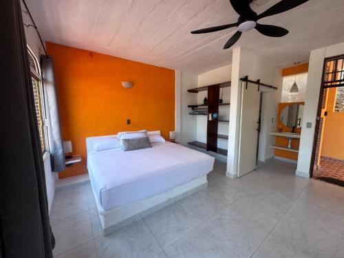 a bedroom with a white bed and a ceiling fan at Casa Dreamy in Zihuatanejo