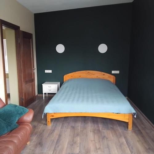 a bedroom with a bed with a wooden head board at The Dacha apartment in Jūrmala
