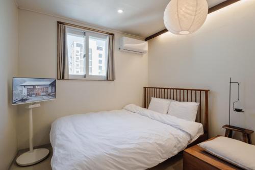 a bedroom with a white bed and a window at 포켓서울 문래점 in Seoul