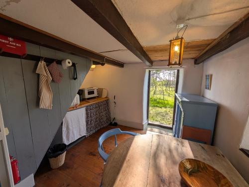 a room with a table and a kitchen with a window at Lillstugan på Lansa in Aurgrund