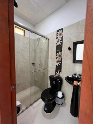 a bathroom with a shower and a toilet and a sink at Finca Hotel La Potranca in Acacías