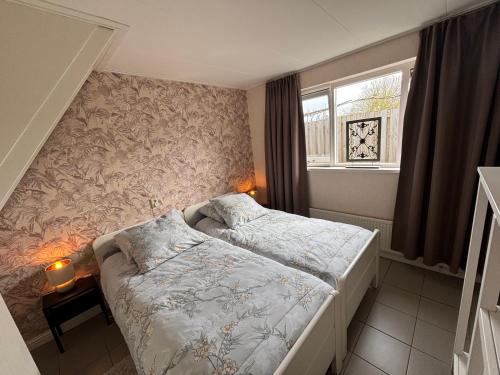 a small bedroom with a bed and a window at B&B Kleine Vliet in Medemblik