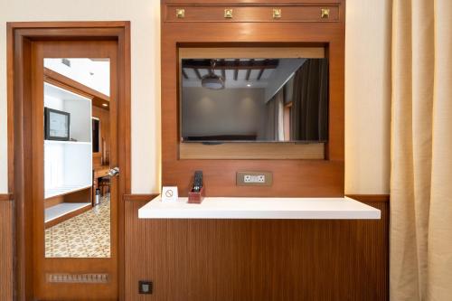 a room with a tv and a mirror at SKI - Sivakavi Iconic in Pondicherry