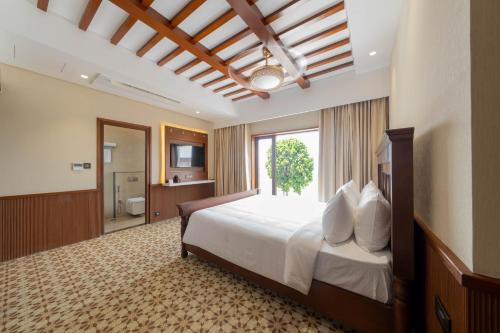 a bedroom with a large bed and a bathroom at SKI - Sivakavi Iconic in Pondicherry