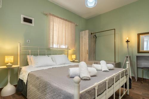 a bedroom with a large bed with white pillows at Elia Grove House in Néa Khilí