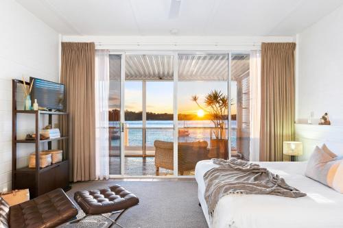a bedroom with a bed and a view of the ocean at Bay Breeze Boutique Accommodation in Batemans Bay