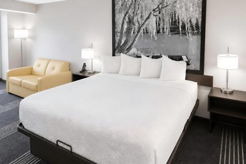a hotel room with a large bed and a chair at Super 8 by Wyndham Salina I-70 in Salina
