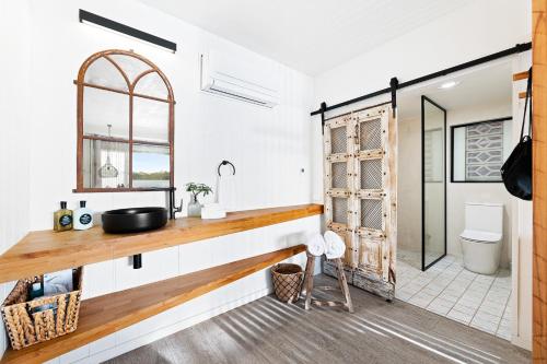 a bathroom with a sink and a mirror at Bay Breeze Boutique Accommodation in Batemans Bay