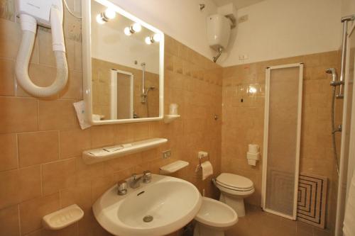 a bathroom with a sink and a toilet and a mirror at Villa Nencini in Volterra