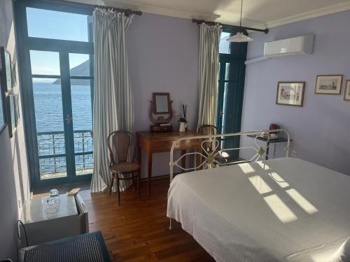 a bedroom with a bed and a view of the ocean at Hotel Aliki in Symi
