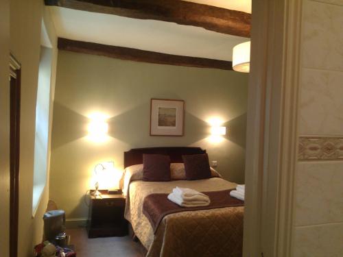 a bedroom with a bed and a lamp at The Kings Head Hotel in Ross on Wye