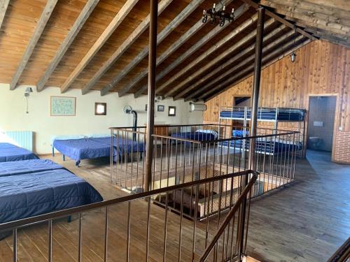 a room with three beds in a barn with wooden ceilings at Quinta del Quinoto in Pajares de Adaja