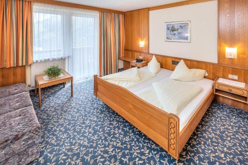 um quarto com uma cama grande num quarto em Kinderhotel Sailer em Wenns